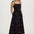 Woman wearing a black floral dress on a white background