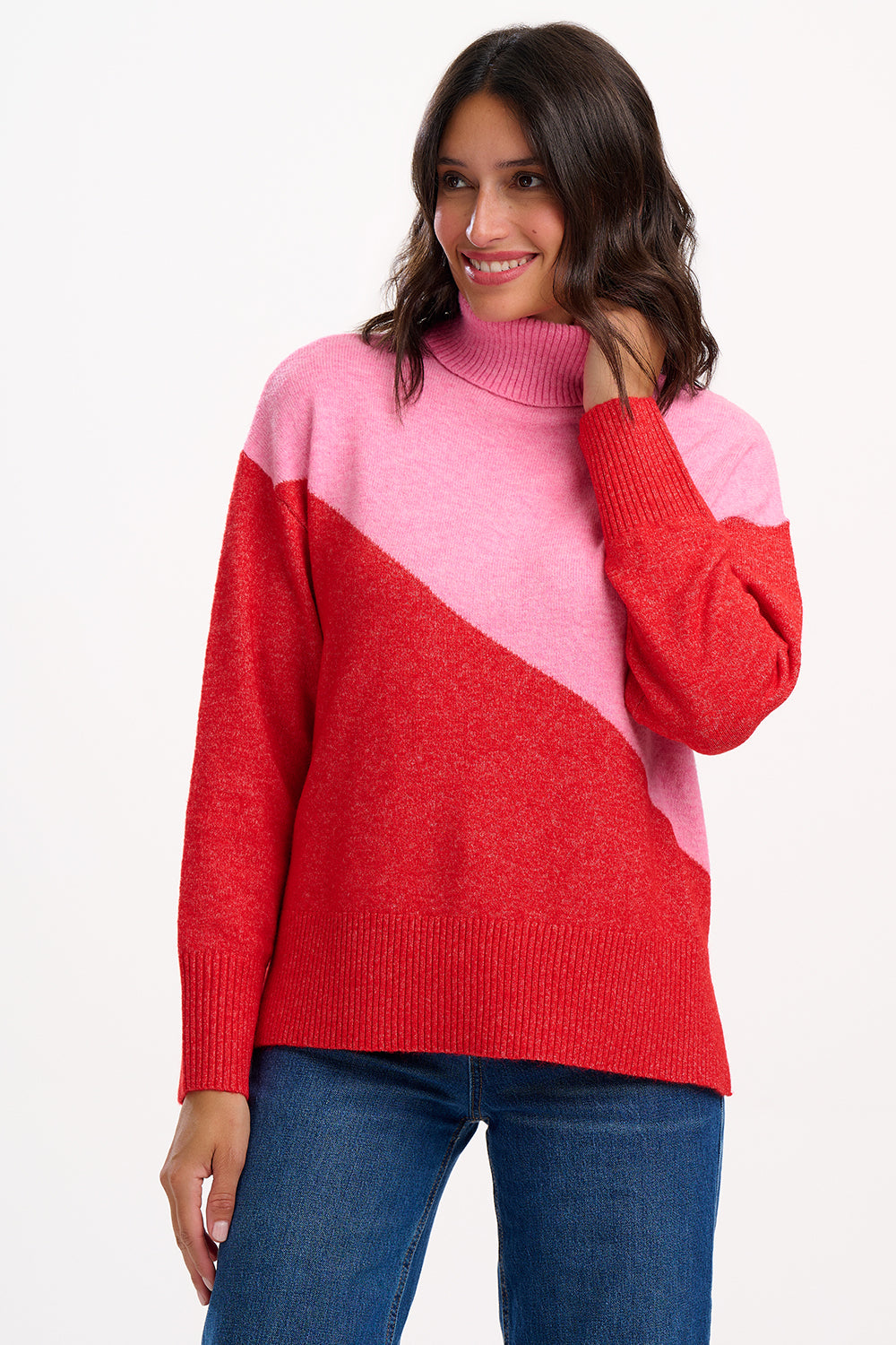 Woman wearing a red and pink color-blocked sweater on a white background