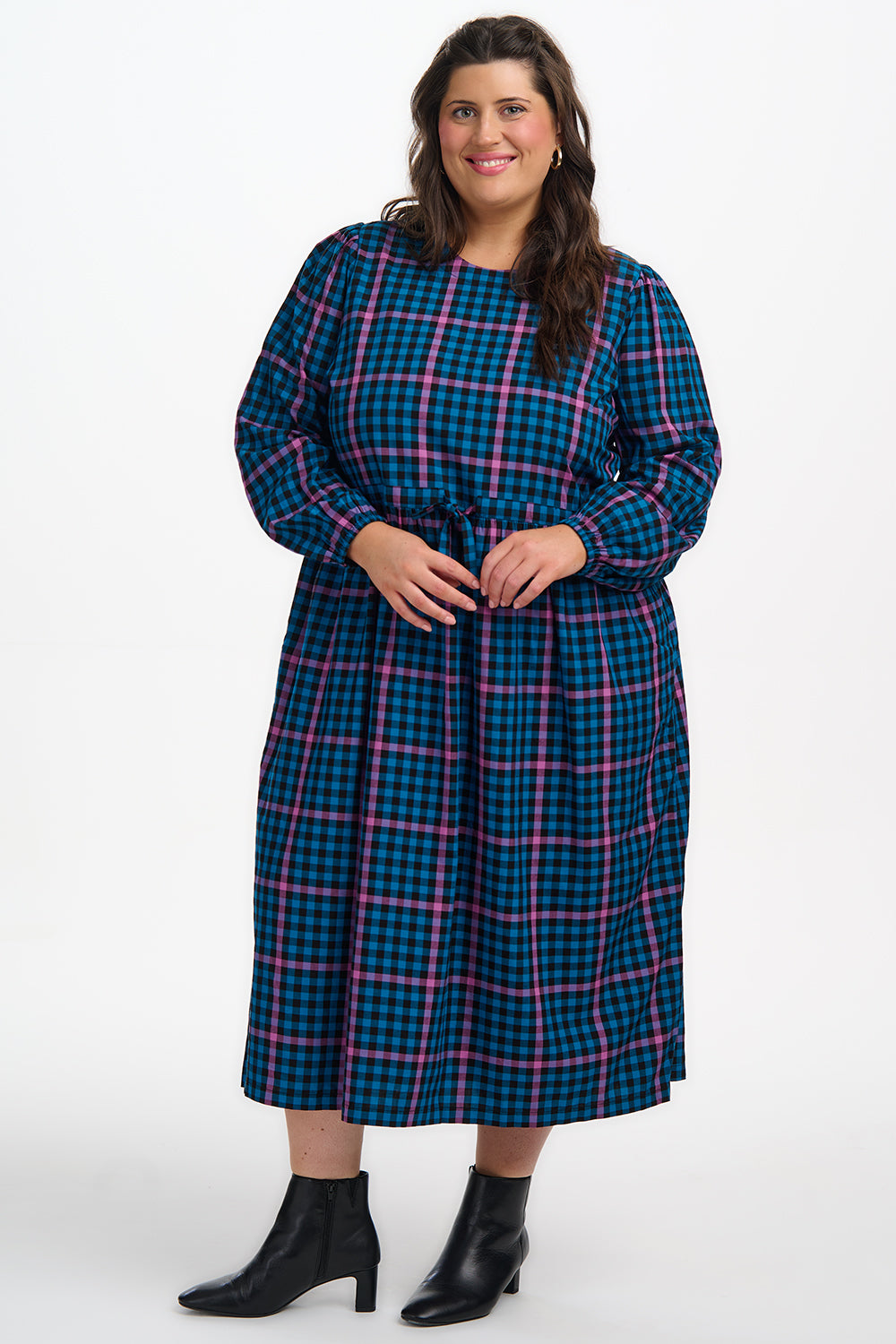 Woman wearing a blue and pink plaid dress on a white background