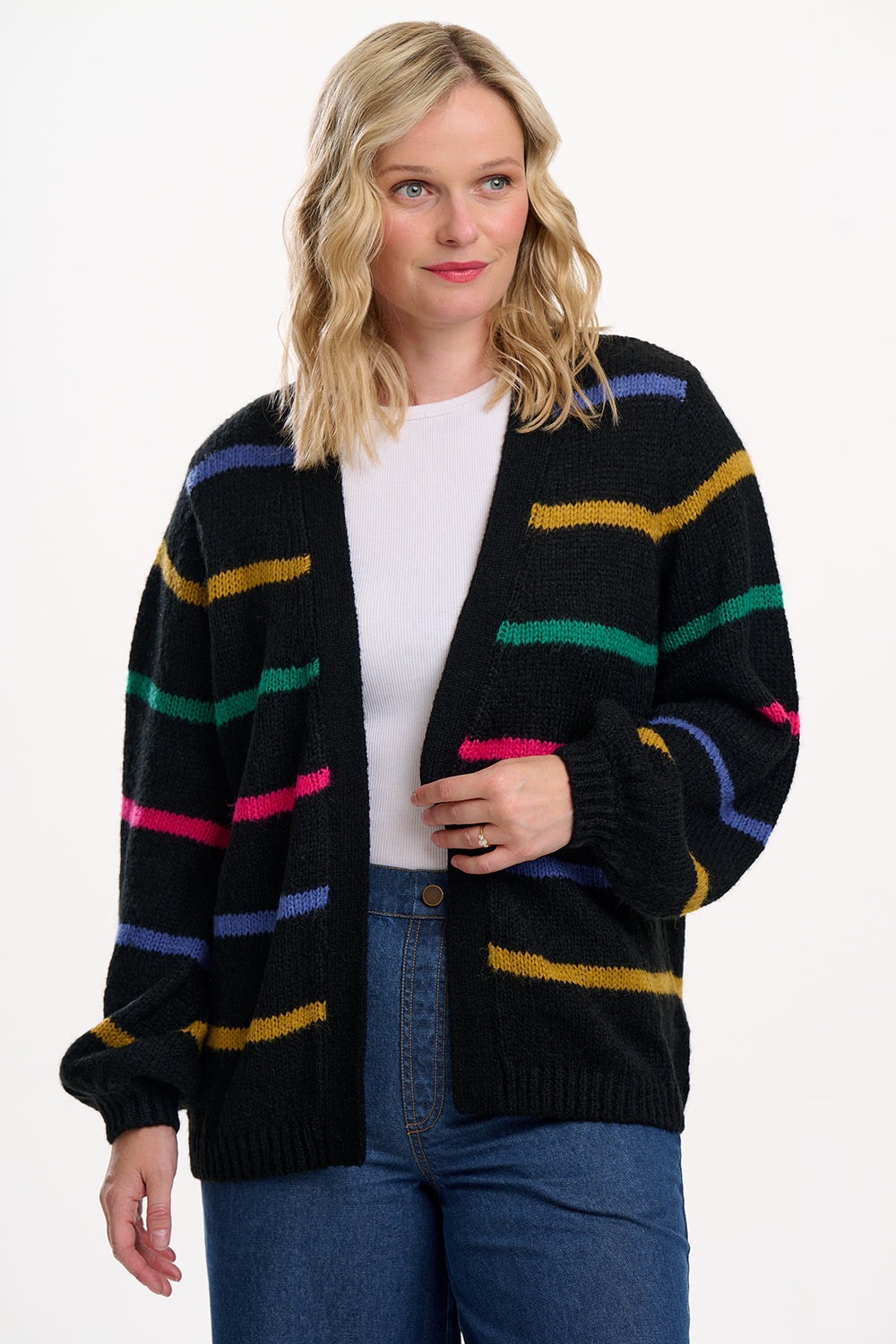 Woman wearing a black cardigan with colorful stripes on a white background