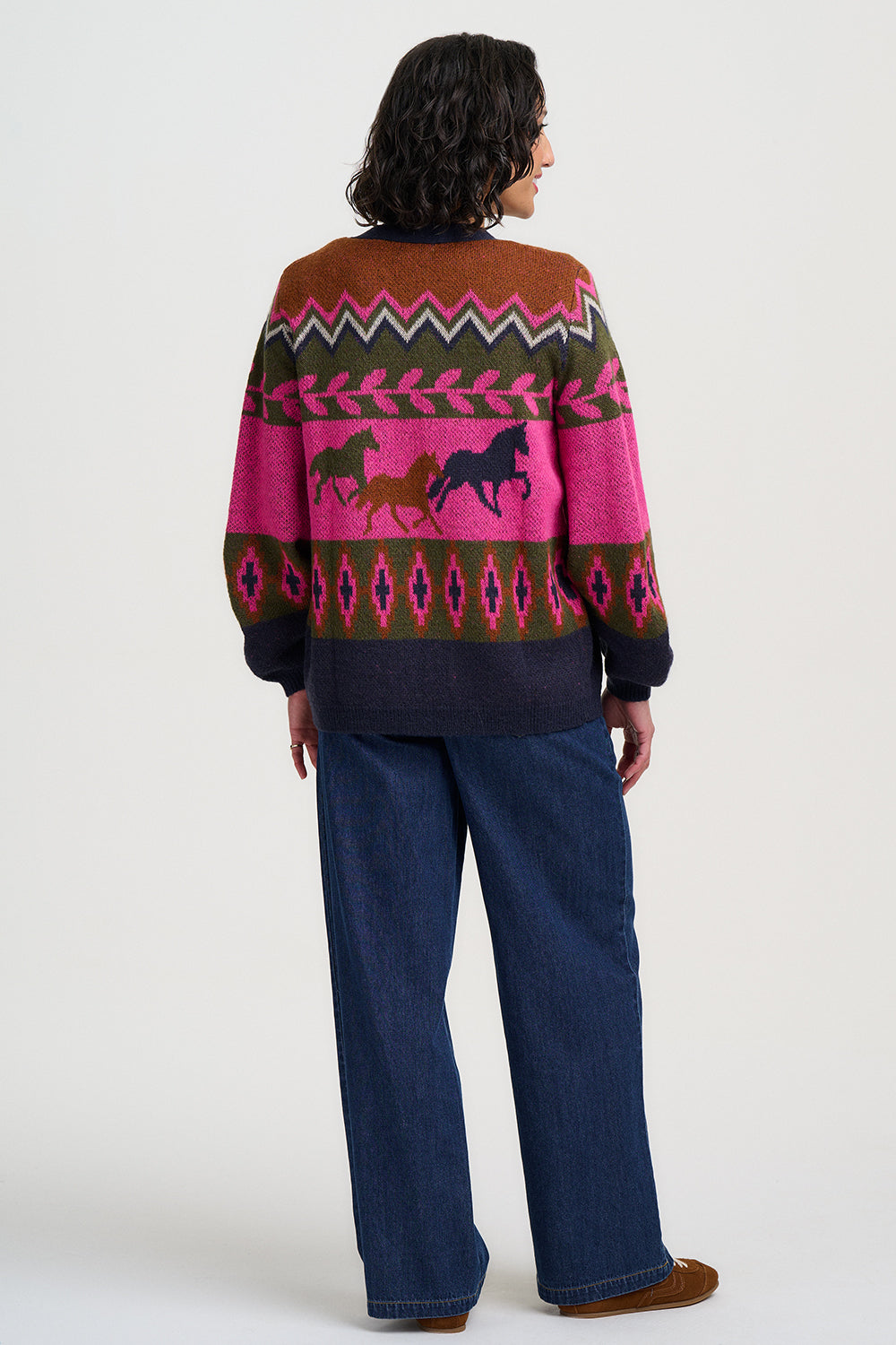Person wearing a colorful sweater with horse design on a white background
