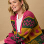 A model wearing a multicoloured cardigan with sun leopard pattern, balloon sleeves, and a relaxed fit.