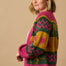 A model wearing a multicoloured cardigan with sun leopard pattern, balloon sleeves, and a relaxed fit.