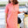 Woman in a pink dress standing next to a yellow scooter on a street.