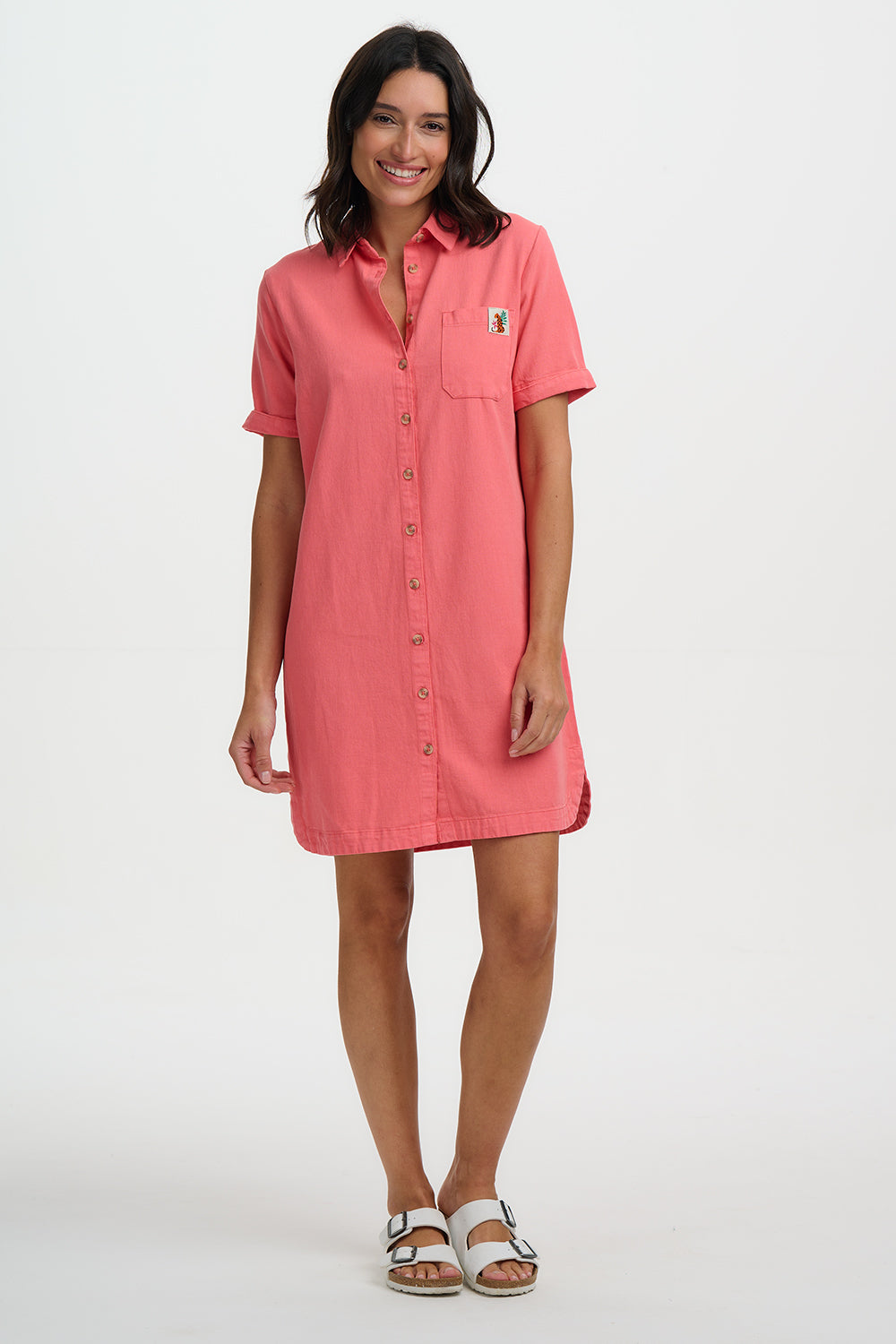 Woman wearing a pink shirt dress on a white background