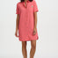 Woman wearing a pink shirt dress on a white background