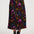 Person wearing a colorful floral skirt on a white background