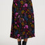 Person wearing a colorful floral skirt on a white background