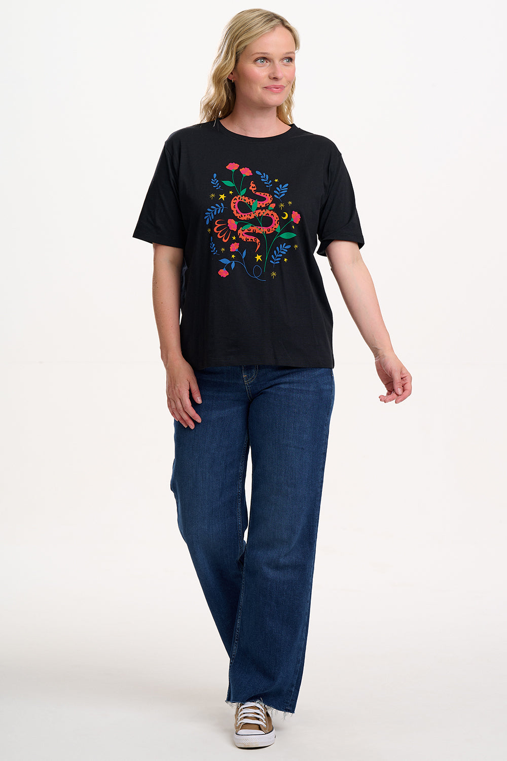 Person wearing a black t-shirt with a colourful snake design on a white background