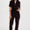 Woman wearing a dark brown jumpsuit on a white background