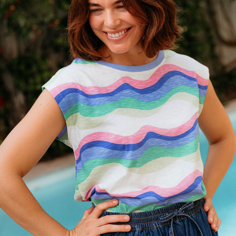 Woman wearing a colorful striped shirt by a poolside