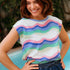 Woman wearing a colorful striped shirt by a poolside