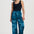Woman wearing blue patterned pants and a black top on a white background