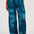 Teal pants with a pattern worn by a person on a white background