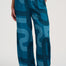 Teal pants with a pattern worn by a person on a white background