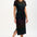 Woman wearing a black dress with colorful fish pattern on a white background