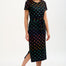 Woman wearing a black dress with colorful fish pattern on a white background