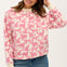 A woman wearing an oversized white sweatshirt with a pink leopard print pattern, paired with blue jeans.