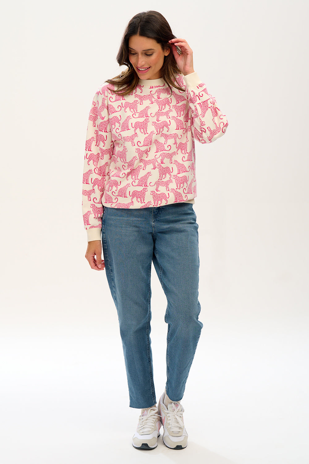woman modeling white sweatshirt with pink leopards on 