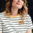 A woman wearing an off-white and navy striped t-shirt with a embroidered leopard on the chest.